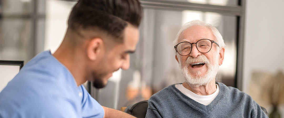 A caregiver with an elderly gentleman both are happy